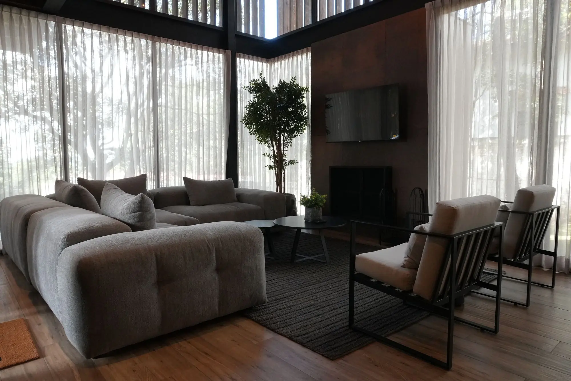 Sala con ventanales de doble altura y cortinas claras