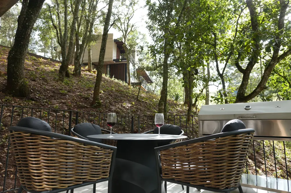 Mesa con dos copas en una terraza entre pinos
